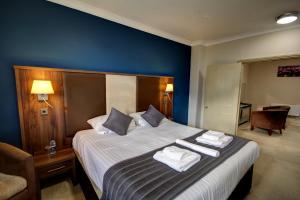 a bedroom with a large bed with towels on it at The Rochford Hotel in Southend-on-Sea