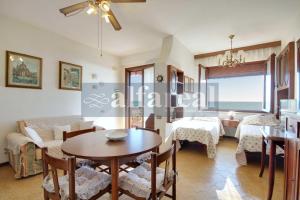 een woonkamer met een tafel en stoelen en een bank bij Elba in Castiglione della Pescaia