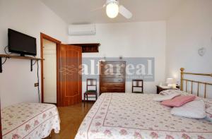 a bedroom with two beds and a flat screen tv at Elba, fronte mare, terrazza e posto auto! by Alfareal in Castiglione della Pescaia