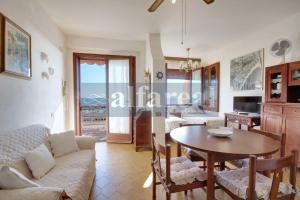 a living room with a couch and a table at Elba, fronte mare, terrazza e posto auto! by Alfareal in Castiglione della Pescaia +19 photos