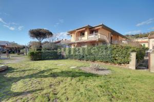 a house with a large yard in front of it at Elba, fronte mare, terrazza e posto auto! by Alfareal in Castiglione della Pescaia