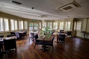 a dining room with tables and chairs and windows at The Rochford Hotel in Southend-on-Sea