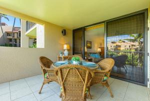 comedor con mesa y sillas en el balcón en Kamaole Sands 6-207 condo, en Wailea