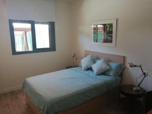 1 Schlafzimmer mit einem Bett mit blauer Bettwäsche und 2 Fenstern in der Unterkunft Ribera del Guadalquivir in Camas