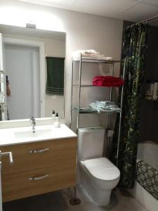 ein Badezimmer mit einem WC, einem Waschbecken und einem Spiegel in der Unterkunft Ribera del Guadalquivir in Camas