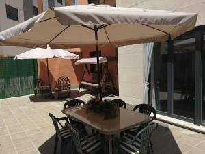 einen Tisch und Stühle unter einem Sonnenschirm auf einer Terrasse in der Unterkunft Ribera del Guadalquivir in Camas