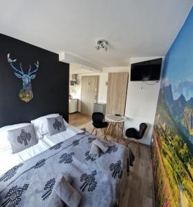 a bedroom with a bed and a table with chairs at Pokoje i apartamenty Wierchy Zakopane in Zakopane