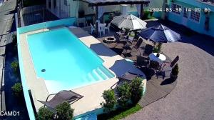 an overhead view of a swimming pool with chairs and umbrellas at 02 - CASA praia PINHEIRA pousada in Palhoça