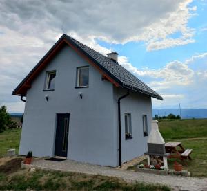 ein weißes Haus mit schwarzem Dach in der Unterkunft Idzikowianka in Idzików