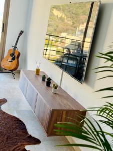 a living room with a wooden table and a guitar at Penthouse over Monaco in Beausoleil