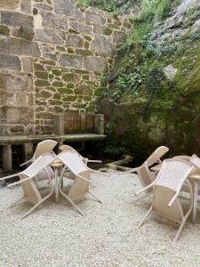 a group of chairs sitting next to a stone wall at Reginita Apartamentos in Arbo