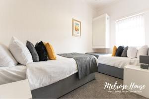 - une chambre avec deux lits et un canapé dans l'établissement Melrose Contractor Accommodation, à Manchester