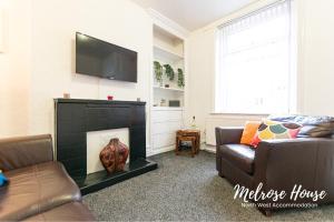 a living room with a couch and a fireplace at Melrose Contractor Accommodation in Manchester