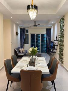 a dining room and living room with a table and chairs at Meridin Bayvue 3 Bedroom in Kampong Kuala Masai