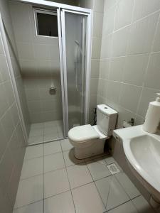 a bathroom with a toilet and a shower and a sink at Meridin Bayvue 3 Bedroom in Kampong Kuala Masai