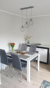 Un comedor con una mesa y sillas blancas. en Apartament Malinka, en Opole