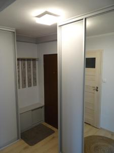 Habitación con puerta corredera de cristal y armario. en Apartament Malinka, en Opole