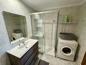 a bathroom with a washing machine and a sink at Your Long Stay Attic Home in Valencia in Valencia +26 photos