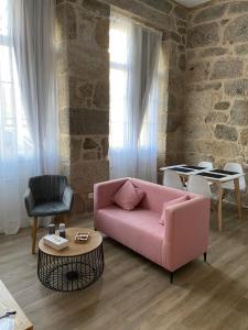 a living room with a pink couch and a table at Reginita Apartamentos in Arbo