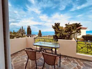 a patio with a table and chairs on a balcony at Orfanos Houses No2 in Koroni