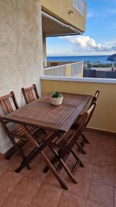 a wooden table and chairs on a balcony with the ocean at Cabo de Palos Apartment in Cabo de Palos