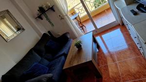 uma sala de estar com um sofá preto e uma mesa de madeira em Cabo de Palos Apartment em Cabo de Palos