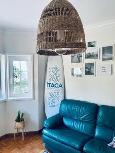 un soggiorno con divano in pelle blu e tavola da surf di Itaca Experience Playa do Cabedelo a Viana do Castelo