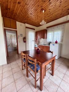 a kitchen with a wooden table and chairs in a room at Orfanos Houses No2 in Koroni