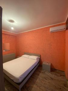 un letto in una camera con parete arancione di La villetta a Caulonia Marina