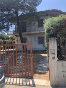 un cancello di fronte a una casa con un albero di La villetta a Caulonia Marina
