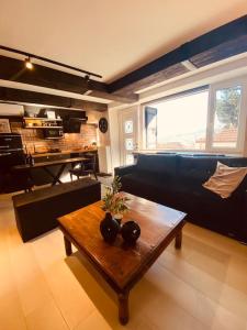 a living room with a coffee table and a piano at calm stone house elemm in Kastoria