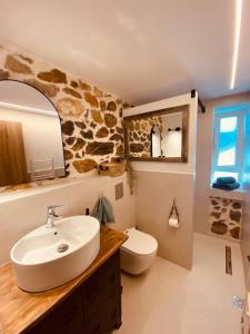a bathroom with a sink and a toilet and a mirror at calm stone house elemm in Kastoria