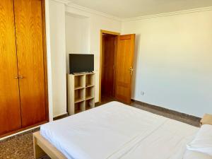 an empty room with a bed and a television at Your Long Stay Attic Home in Valencia in Valencia