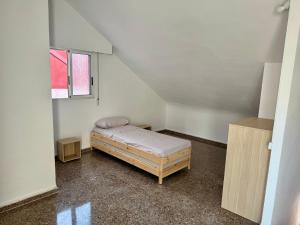 a small room with a bed and a window at Your Long Stay Attic Home in Valencia in Valencia
