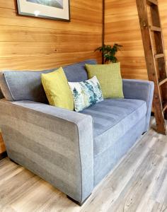 een blauwe bank met gele kussens in een kamer bij Evergreen in Waldport