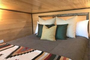 een bed met kussens in een slaapkamer bij Evergreen in Waldport