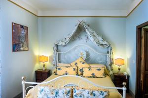 een slaapkamer met een bed met een blauw hoofdeinde bij Locanda Del Molino in Cortona