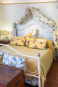 een wit bed met gele en blauwe kussens bij Locanda Del Molino in Cortona