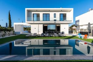 a house with a swimming pool in front of it at Tsiolakki Homes Luxury Villas in Protaras