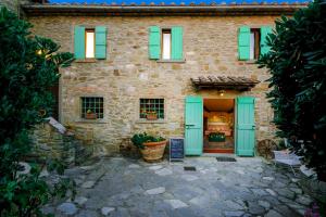 a stone house with green shutters on it at Locanda Del Molino in Cortona