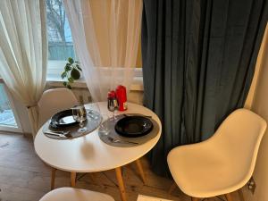 uma pequena mesa branca com duas cadeiras e uma janela em Mieszkanko W Sam Raz em Ruda Śląska