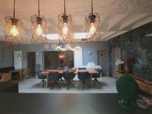 a dining room with a table and chairs and lights at Lazy Olives in Tongeren