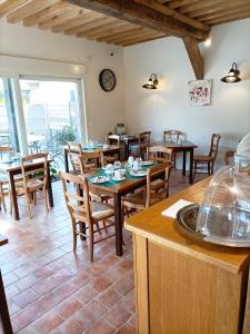 een restaurant met tafels en stoelen en een klok aan de muur bij Auberge du Vieux Tour in Canapville