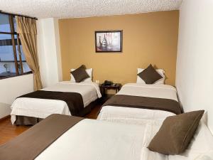 クエンカにあるLoft NASS Atahualpaのベッド2台と窓が備わるホテルルームです。