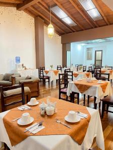 a dining room with tables with white tablecloths at Loft NASS Atahualpa in Cuenca