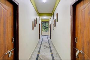 um corredor de um corredor com portas de madeira em OYO Aarshi Palace em Cuttack