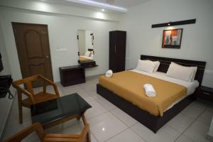 1 Schlafzimmer mit einem großen Bett und einem Badezimmer in der Unterkunft AKAN HOTEL AND RESIDENCE in Wayanad