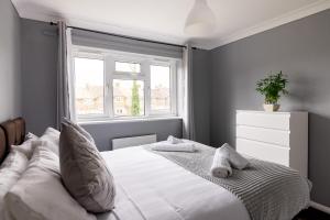 a bedroom with a white bed with a window at The Kilnwood House in Crawley