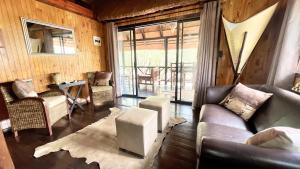 uma sala de estar com um sofá e uma mesa em Kruger Kumba - Lahlekile Nathi em Marloth Park