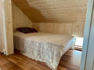 1 dormitorio con 1 cama en una cabaña de madera en Suojelumetsän sylissä oleva talo lähellä vesistöjä, en Keuruu